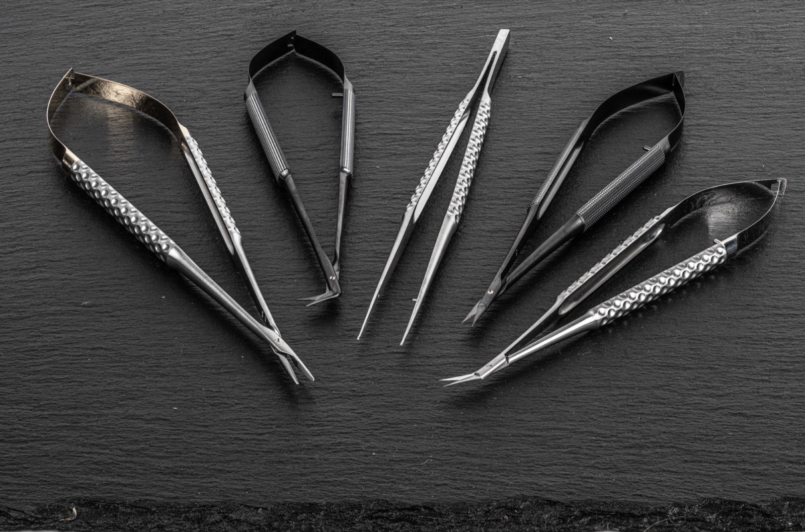MICROQORE Instrumenten-Kollektion – Nadelhalter, Pinzetten und Scheren auf Schiefer
