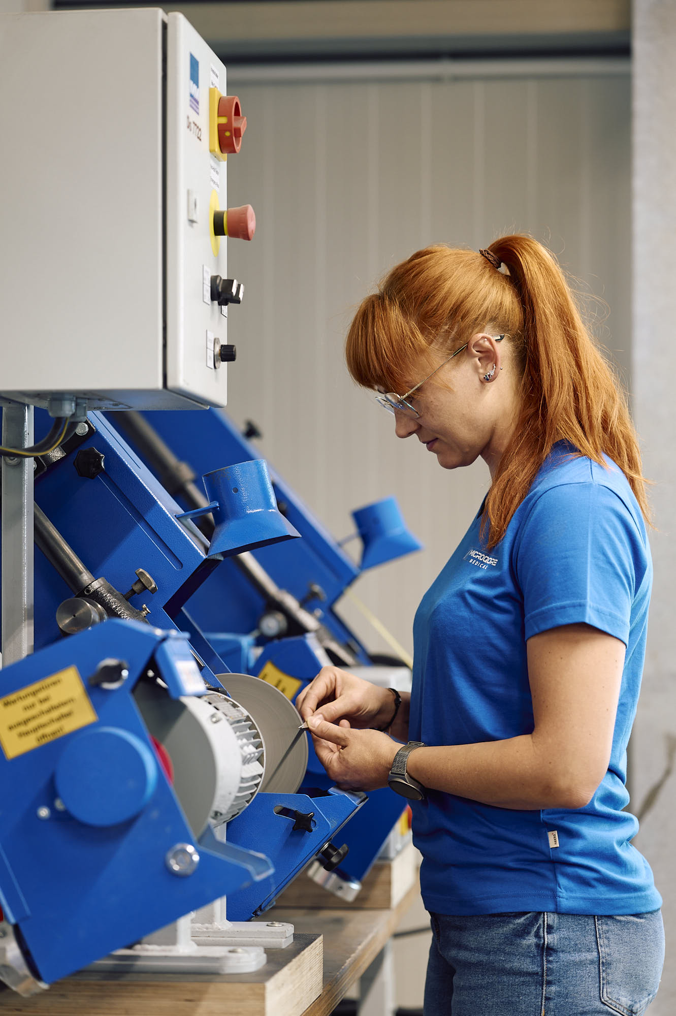 Mitarbeiterin an Schleifmaschine