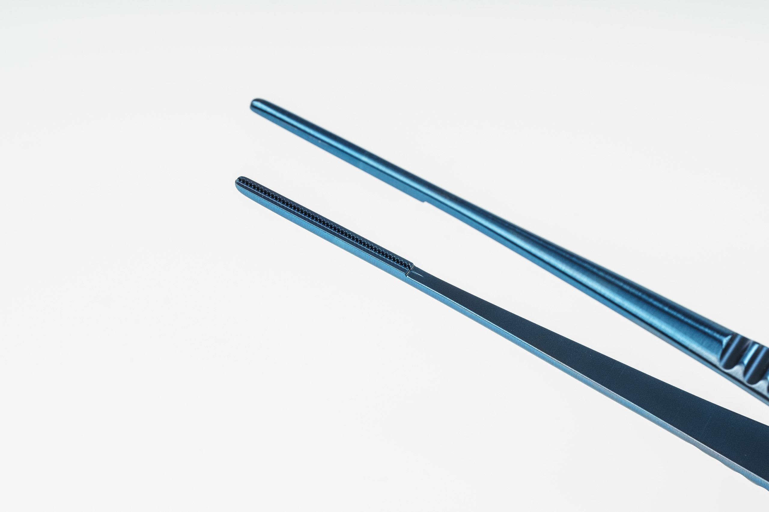 MICROQORE Titan-Pinzette Spitzendetail – Blaue Titan-Oberfläche in Makroansicht